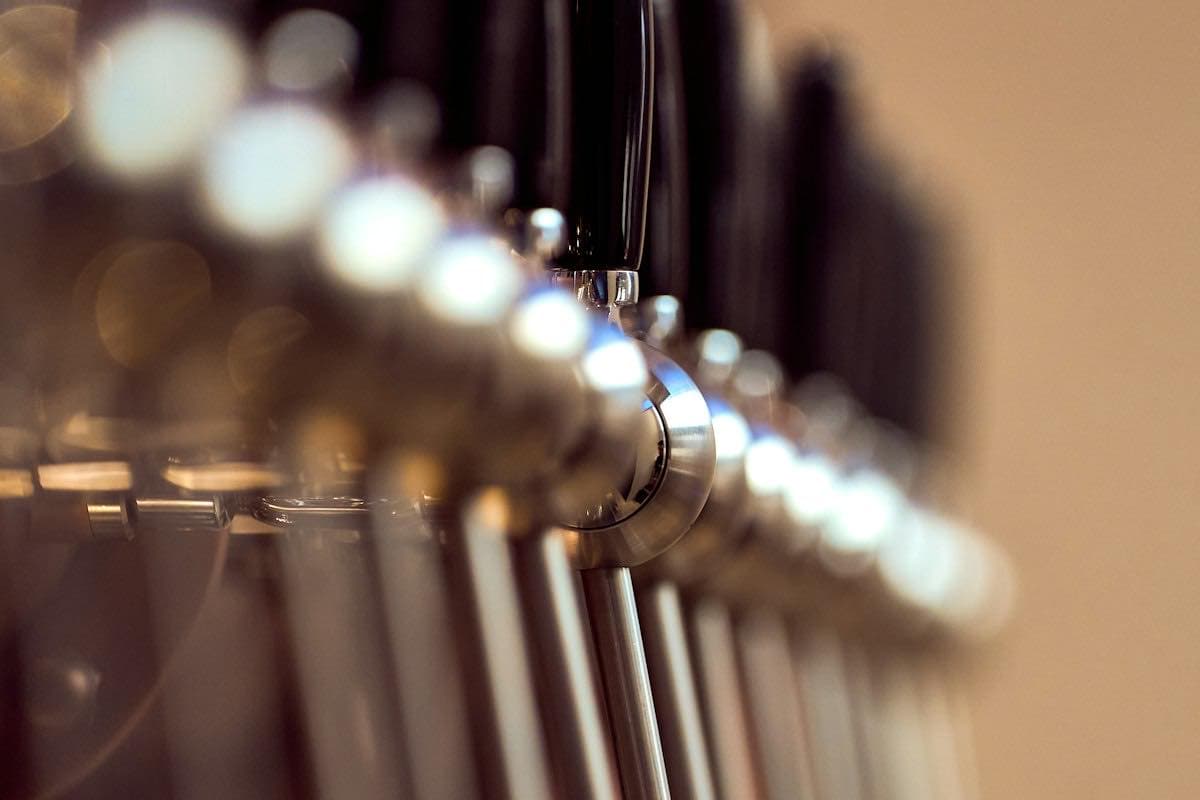 A row of beer taps at a bar