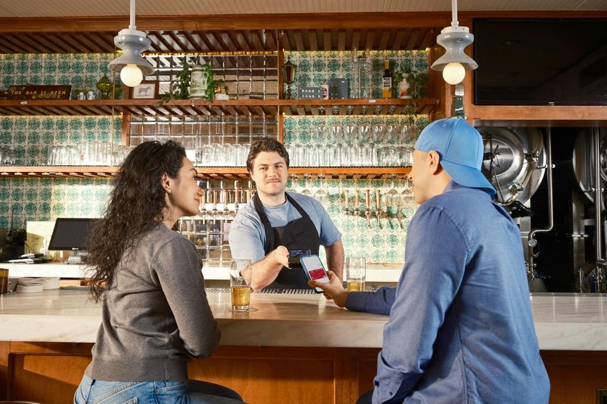A bartender serving drinks at a bar
