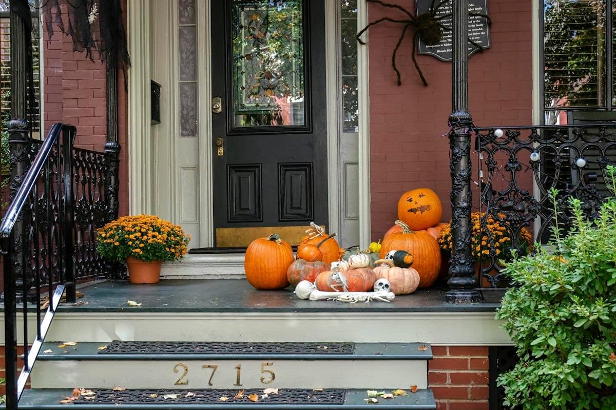 A front porch decorated with pumpkins and gourds