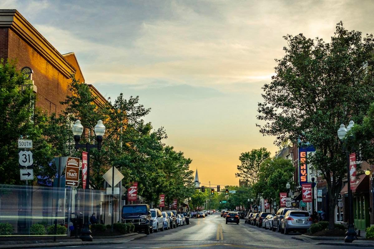 A small-town main street lined with storefronts at dusk