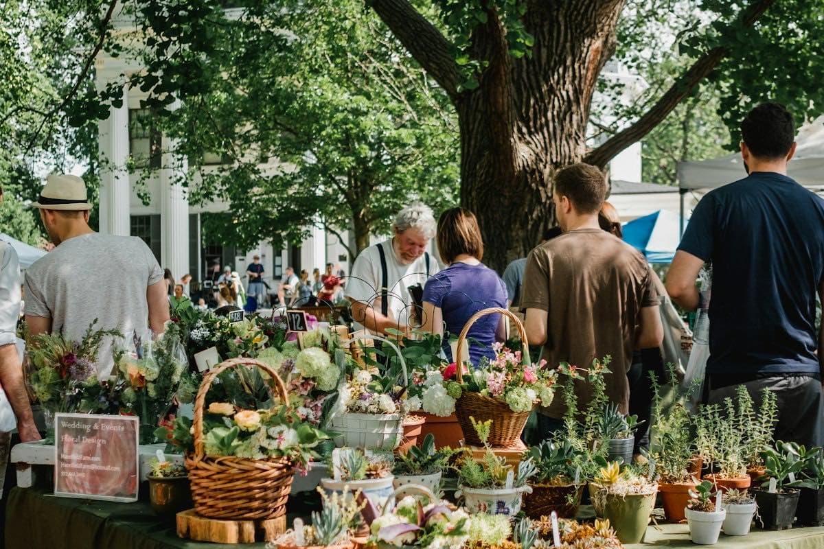 Shoppers at a farmers market produce table