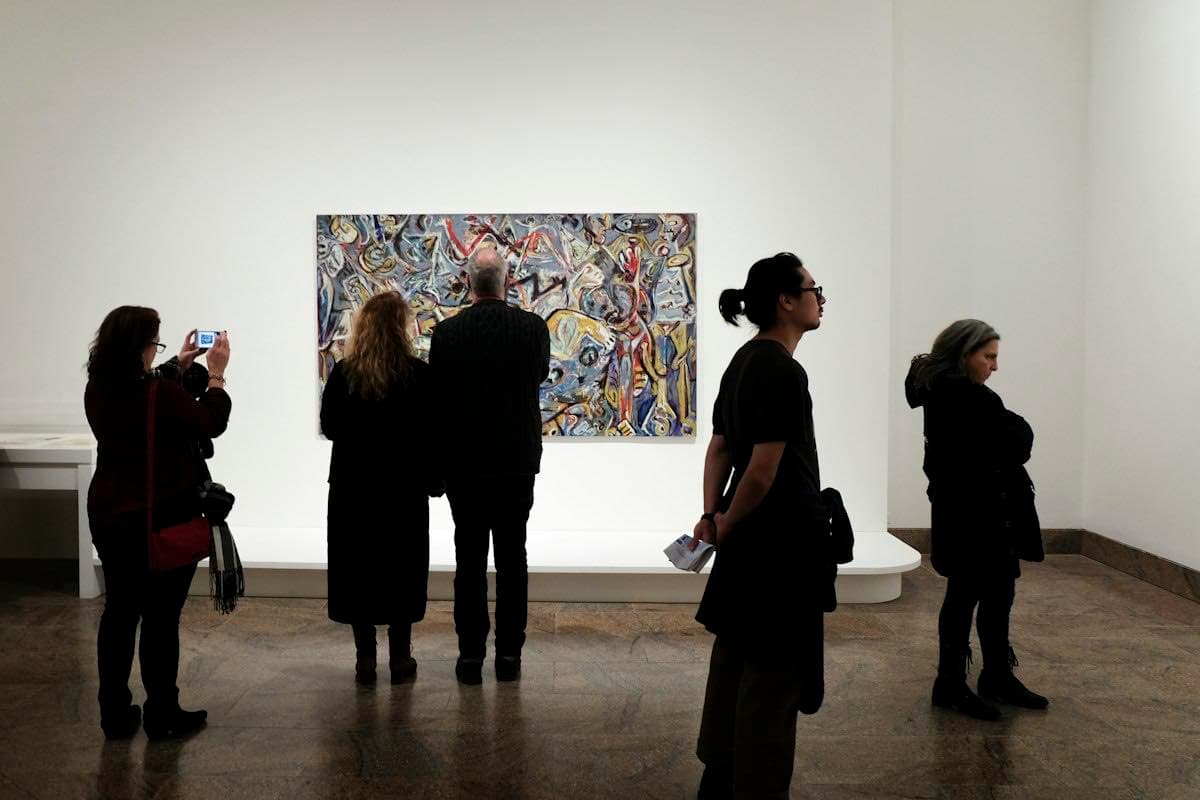 People viewing a painting at a gallery opening