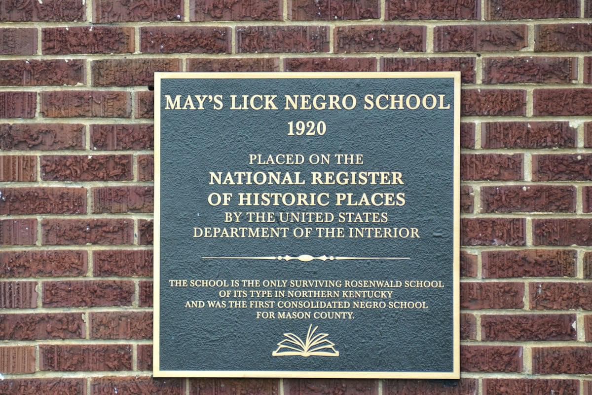 A bronze historical marker on a brick wall