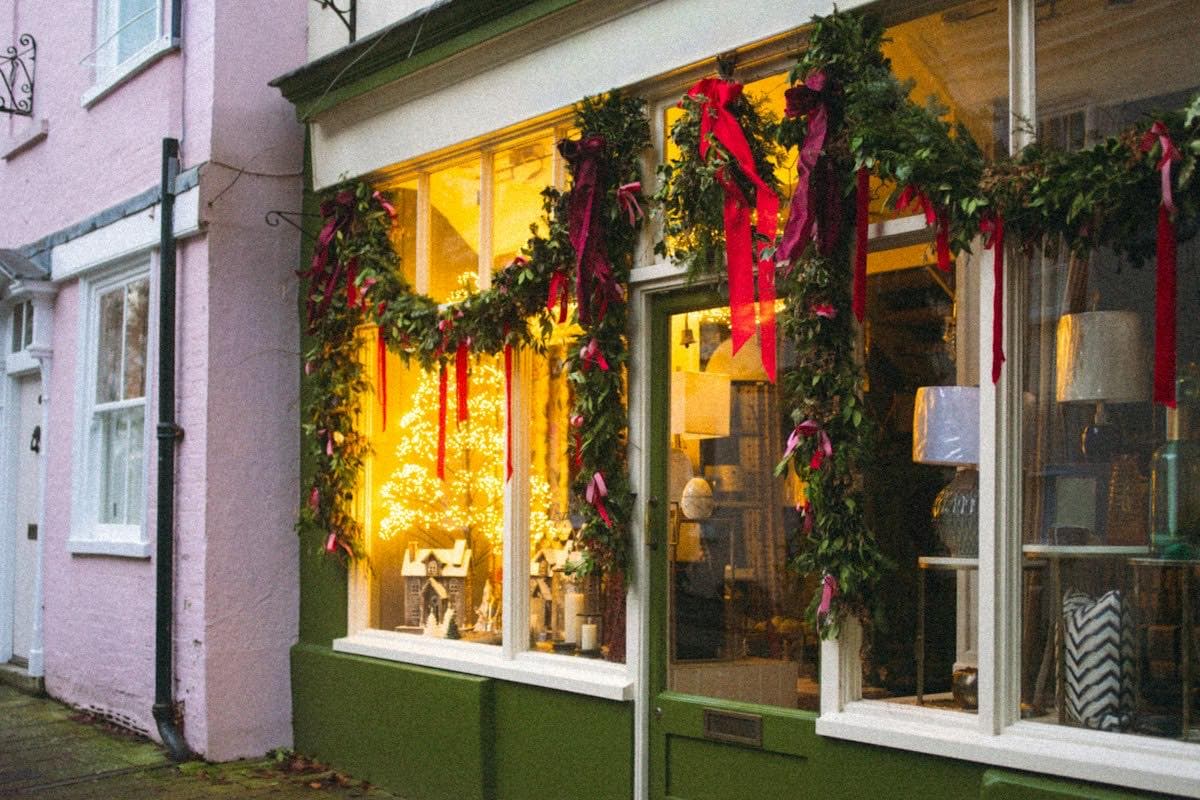 A shop window decorated with holiday garlands and lights