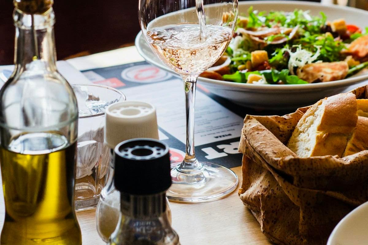 A server pouring wine at a restaurant table