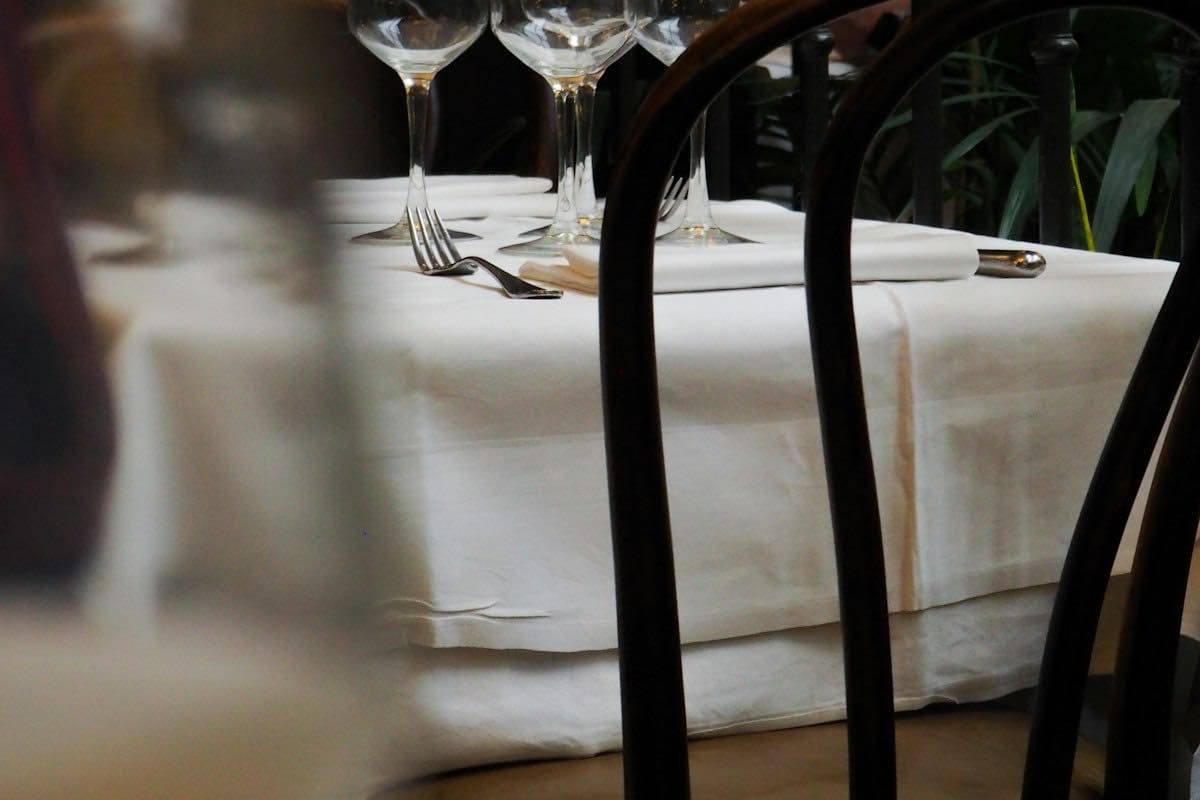 A restaurant table set with wine glasses