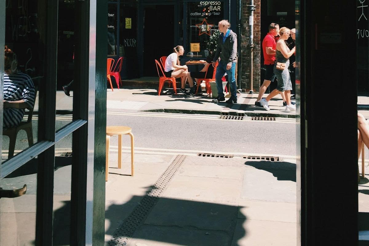 People sitting on a bench outside a shop