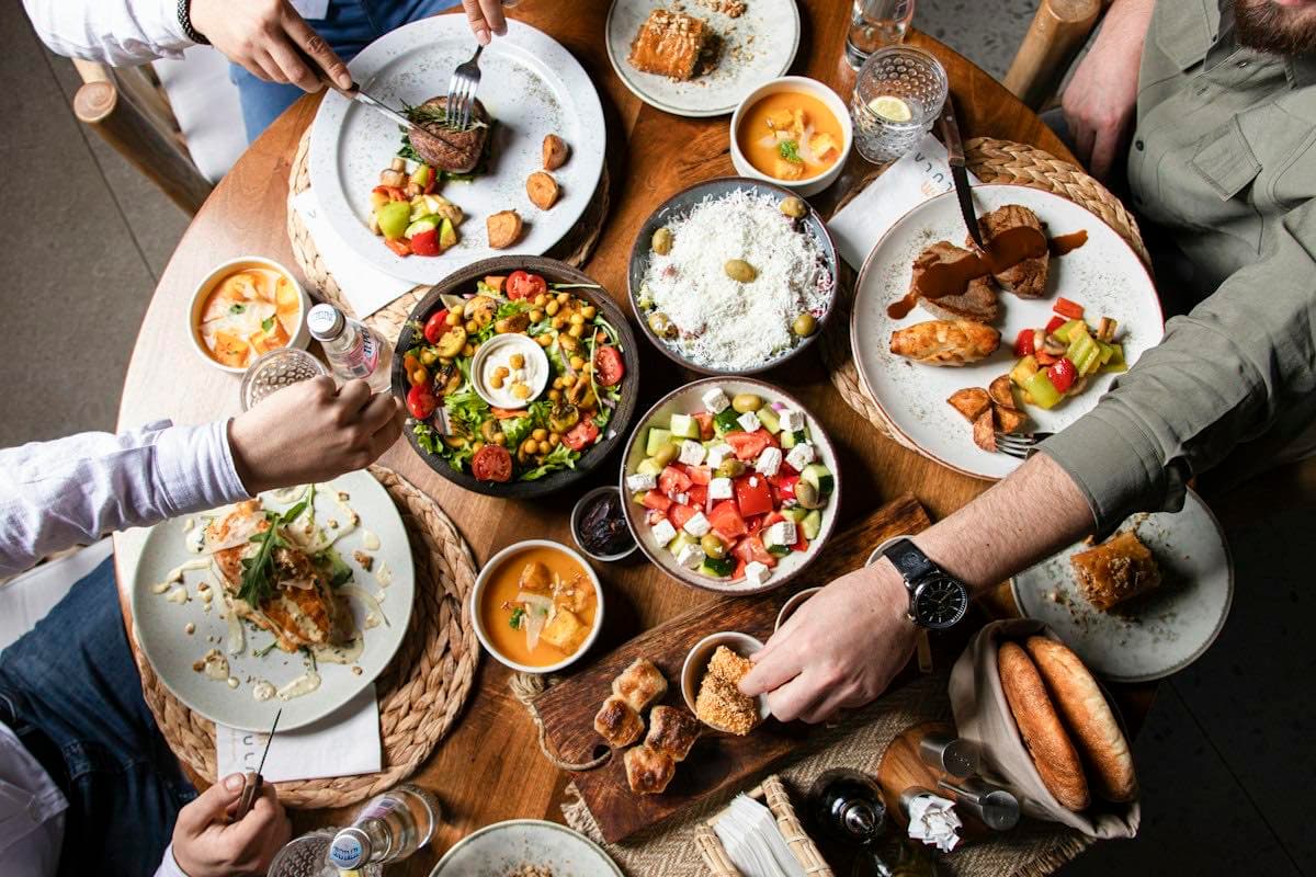 Friends sharing dishes at a restaurant table